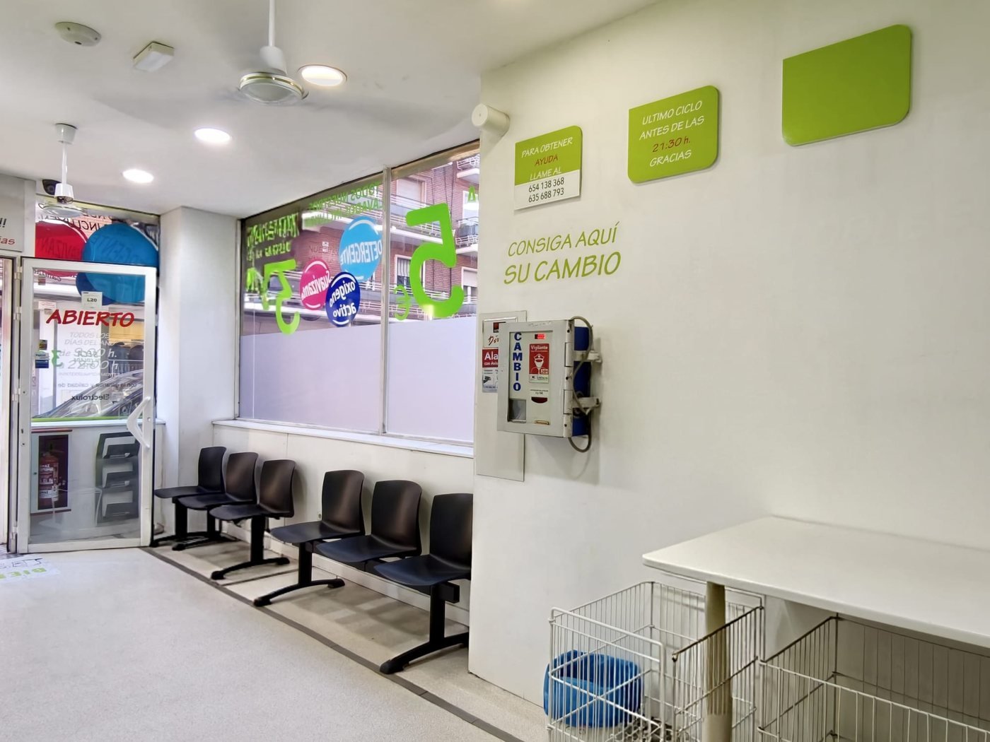 Zona de espera de Colada Exprés con asientos cómodos y mesa de doblado donde esperas tu colada